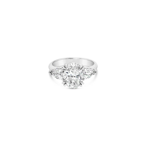 18ct white gold three stone diamond ring featuring a 2.17ct oval centre diamond with pear cut diamond side stones in tiered cap-and-claw settings.