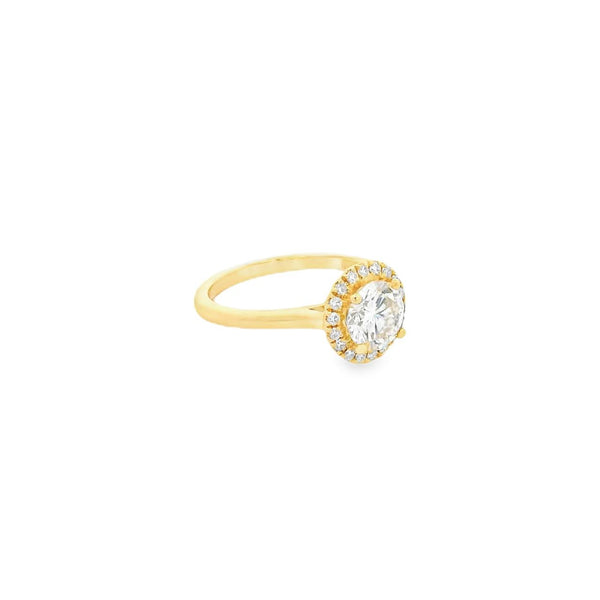 18ct yellow gold diamond halo ring featuring a 1.30ct round brilliant cut centre diamond with a surrounding halo of smaller diamonds.