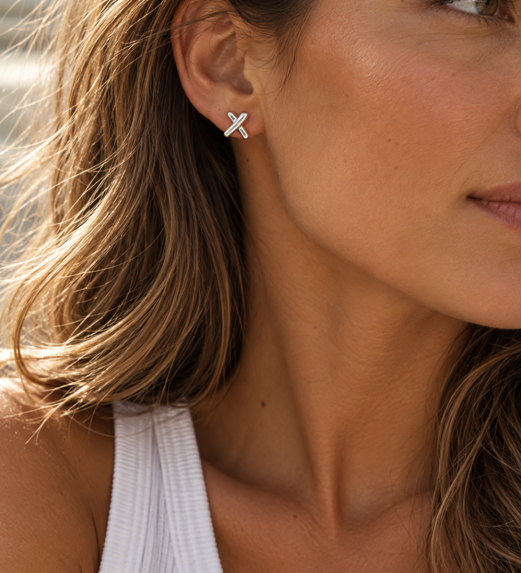 Sterling silver Cross Kiss stud earrings with polished intersecting design.