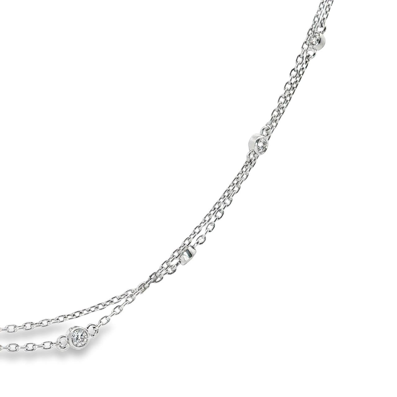 Platinum double strand diamond station necklet with twelve bezel set natural round brilliant cut diamonds on fine trace chains, 40cm long.