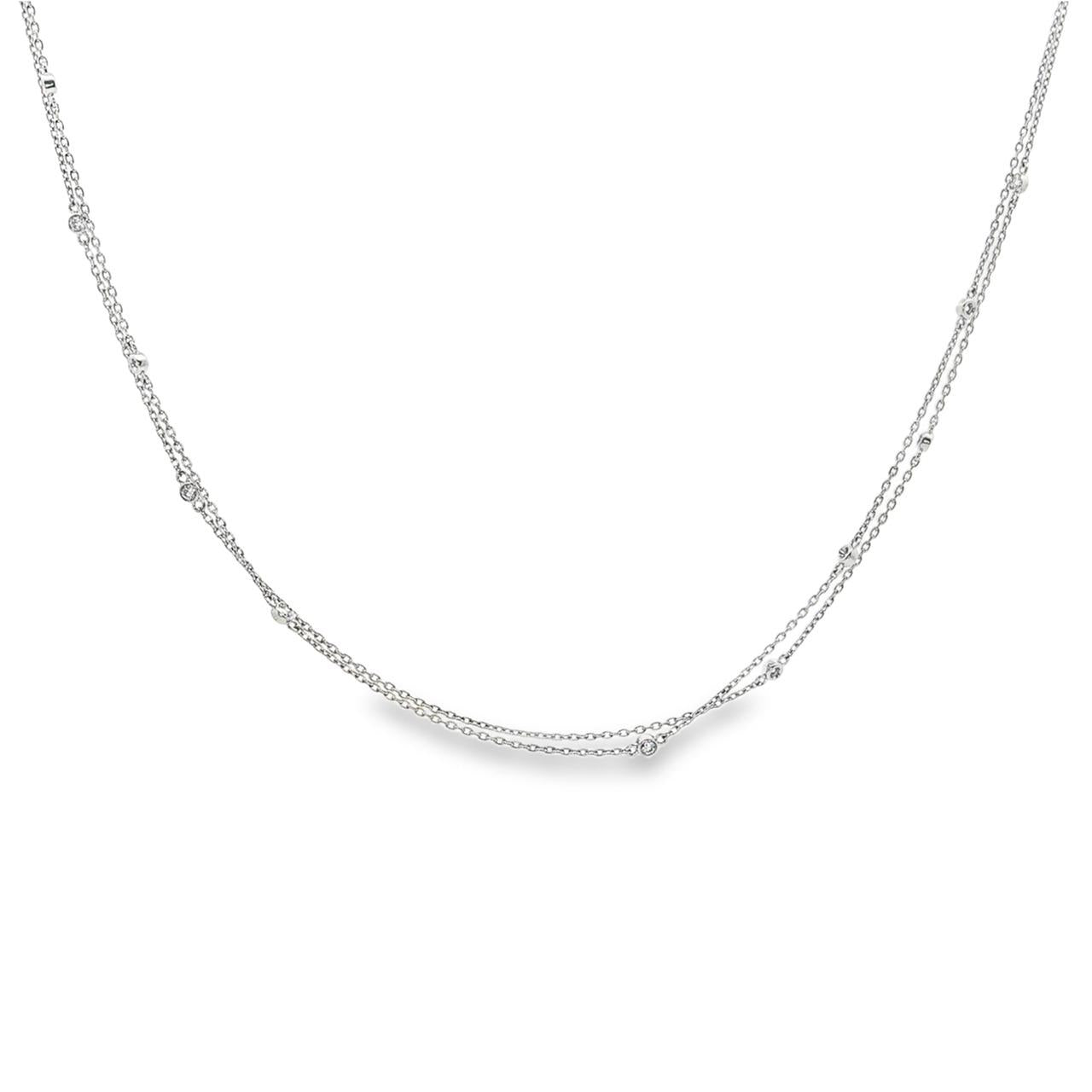 Platinum double strand diamond station necklet with twelve bezel set natural round brilliant cut diamonds on fine trace chains, 40cm long.