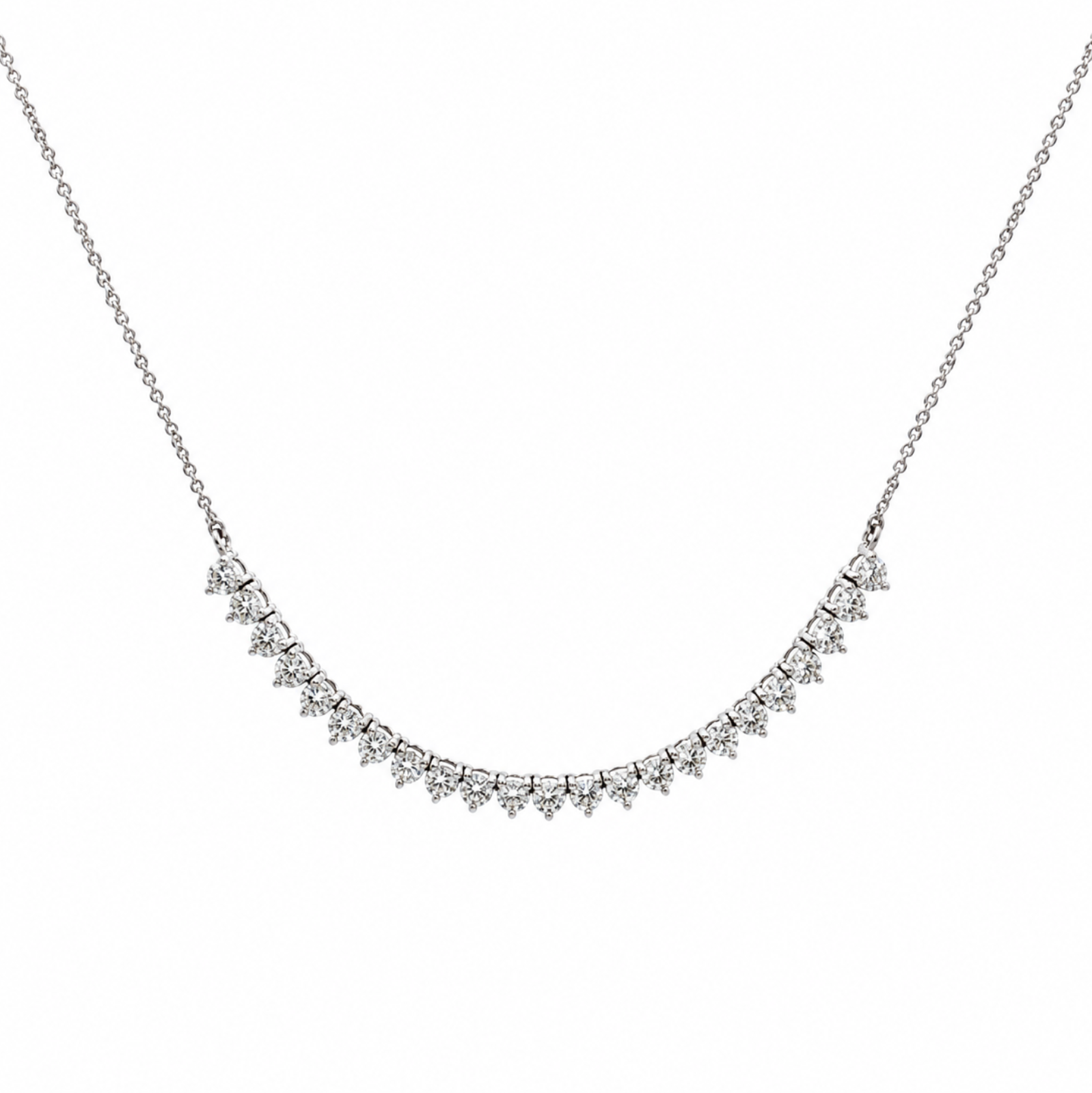 A delicate white gold necklace featuring a curved line of diamonds in a prong setting, suspended from a fine chain against a plain white background.