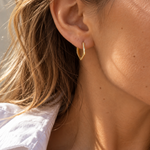 9ct yellow gold pentagon huggie earrings with a flat, angular profile and polished finish, measuring 17mm in diameter.