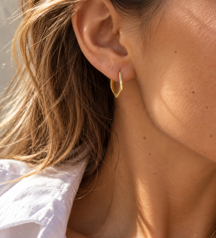 9ct yellow gold pentagon huggie earrings with a flat, angular profile and polished finish, measuring 17mm in diameter.