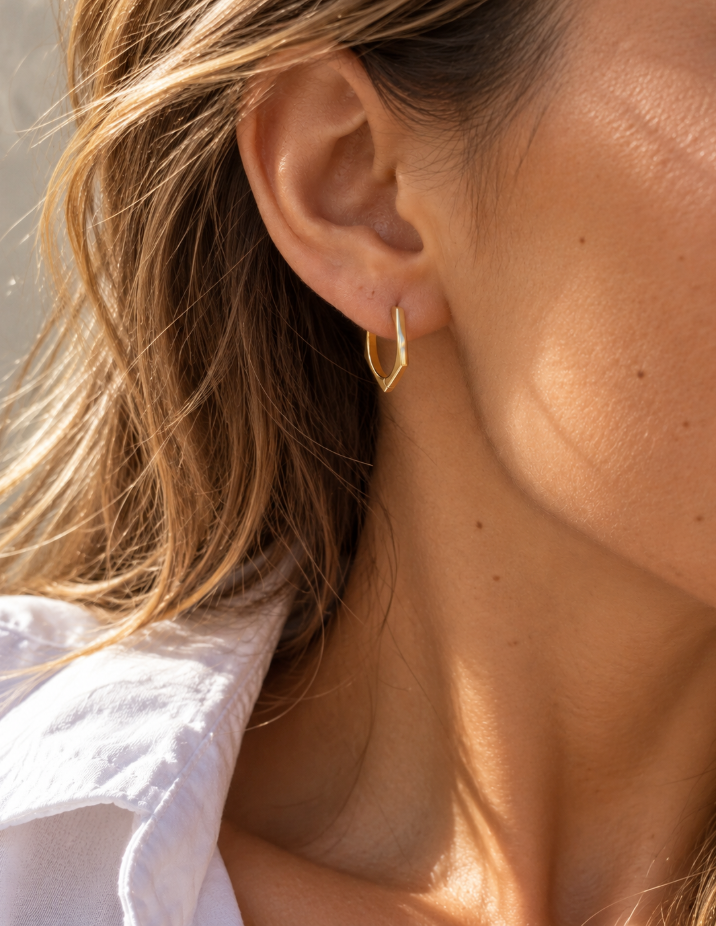 9ct yellow gold pentagon huggie earrings with a flat, angular profile and polished finish, measuring 17mm in diameter.