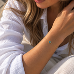 9ct yellow gold fine trace link bracelet with a blue Evil Eye centre charm and bolt ring clasp.