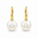 A pair of gold huggie hoop earrings with large, lustrous white South Sea pearls hanging from gold posts, shown on a clean white background.