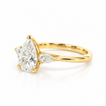 Three-stone pear diamond engagement ring in 18ct yellow gold with vertically set centre diamond and horizontal pear-shaped side stones.