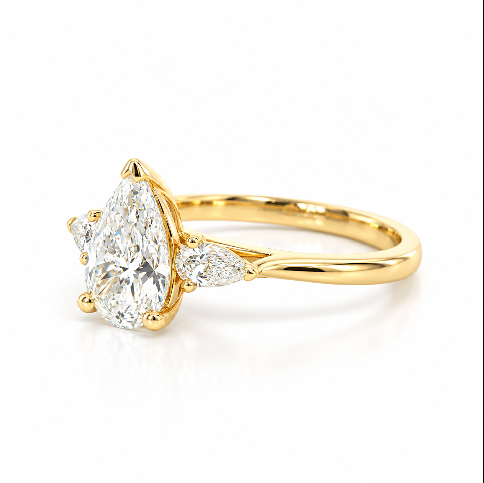 Three-stone pear diamond engagement ring in 18ct yellow gold with vertically set centre diamond and horizontal pear-shaped side stones.