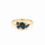 18ct yellow gold ring featuring a random cluster of Australian blue sapphires in pear, round, and marquise cuts with diamond accents and a post and bezel undercarriage.