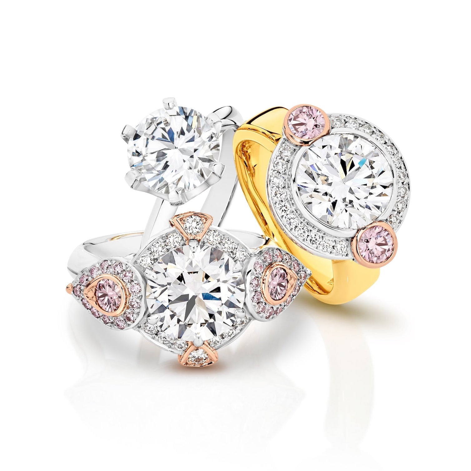 Three diamond rings with gold and rose gold accents on a white background