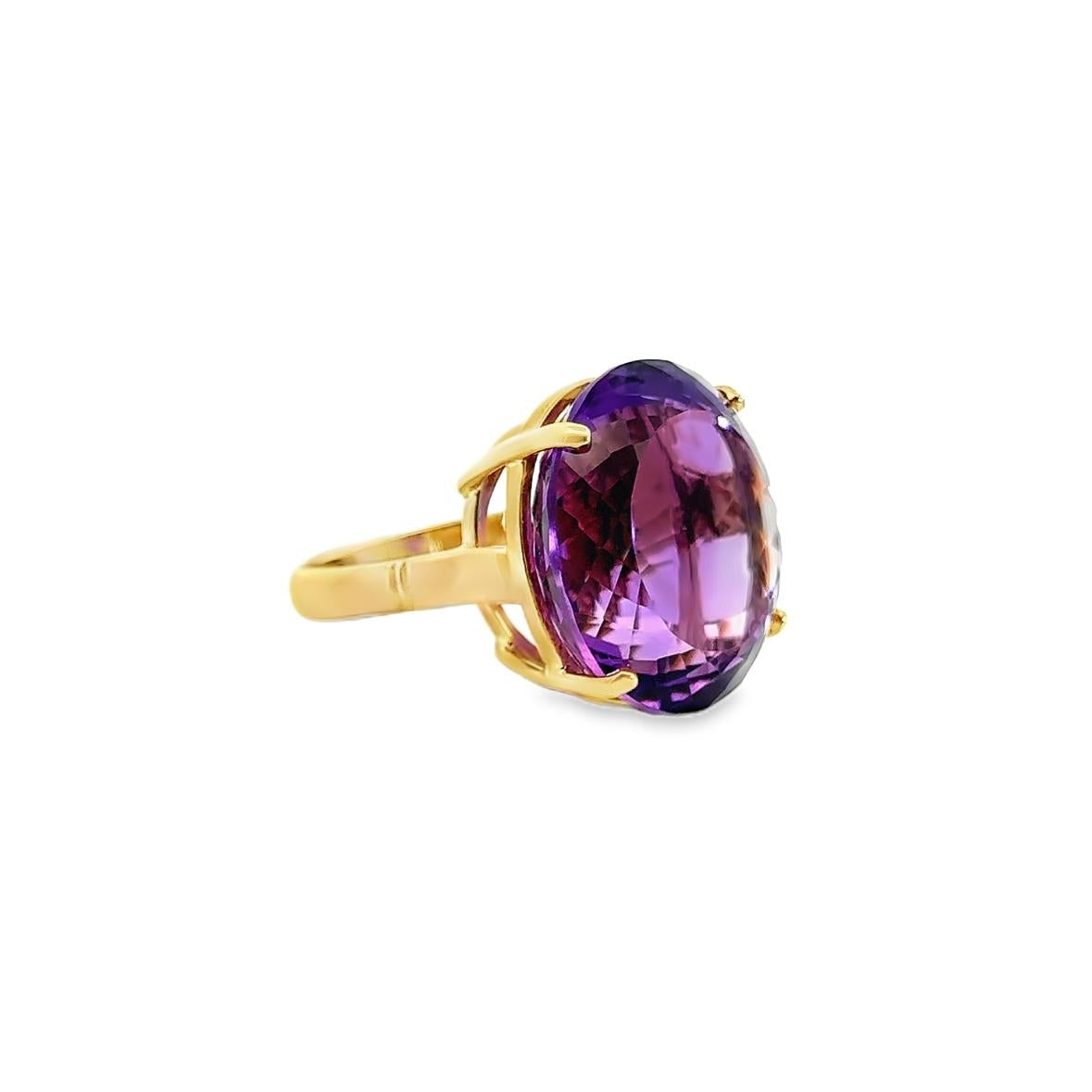 9ct yellow gold ring featuring a large 21.80 x 19.00mm fancy oval cut amethyst in a four-claw setting with engraved shoulder detailing.