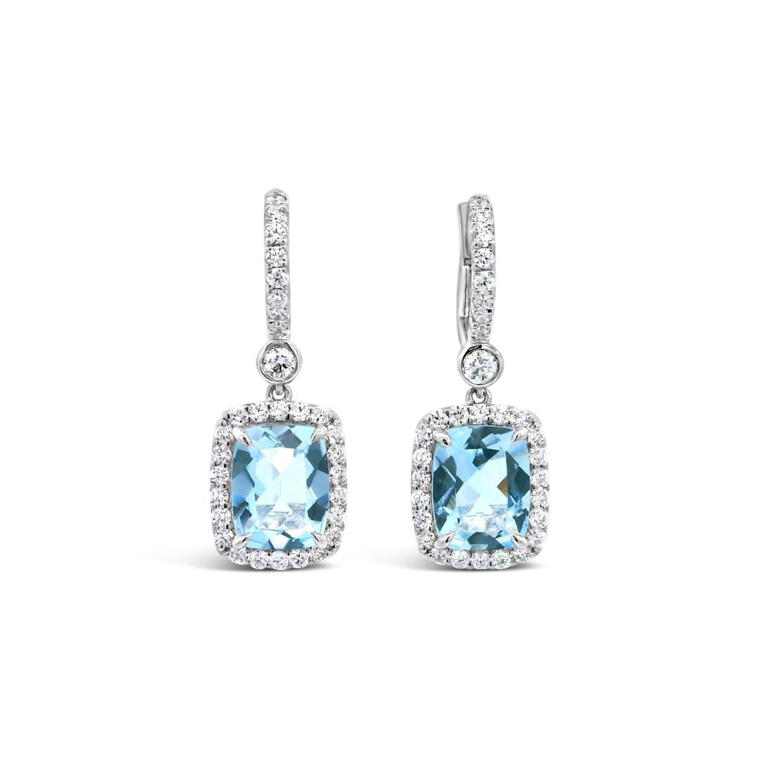 18ct white gold aquamarine and diamond drop earrings featuring cushion cut aquamarines with diamond halos and huggie-style fittings.