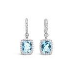 18ct white gold aquamarine and diamond drop earrings featuring cushion cut aquamarines with diamond halos and huggie-style fittings.