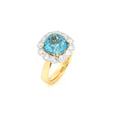 18ct yellow and white gold aquamarine and diamond halo ring featuring a 3.73ct cushion cut green aquamarine with a diamond halo surround.