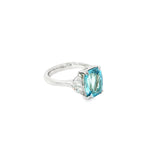 18ct white gold three-stone ring featuring a 3.44ct cushion cut aquamarine with two half moon cut diamond side stones.