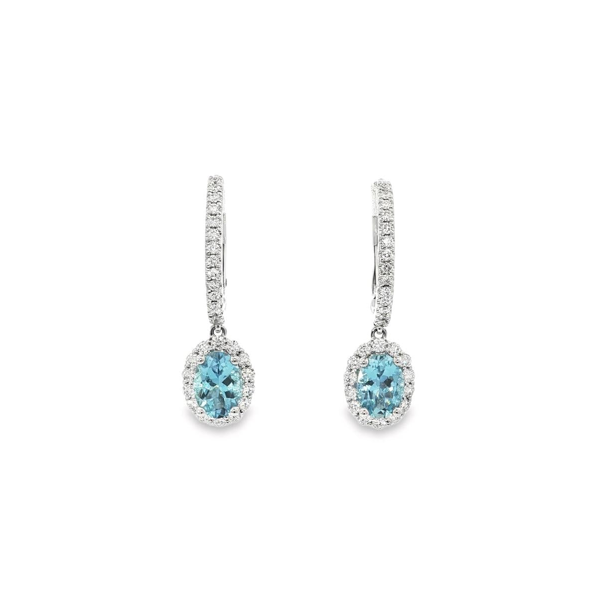 18ct white gold aquamarine and diamond drop earrings with oval blue gemstones and diamond halo