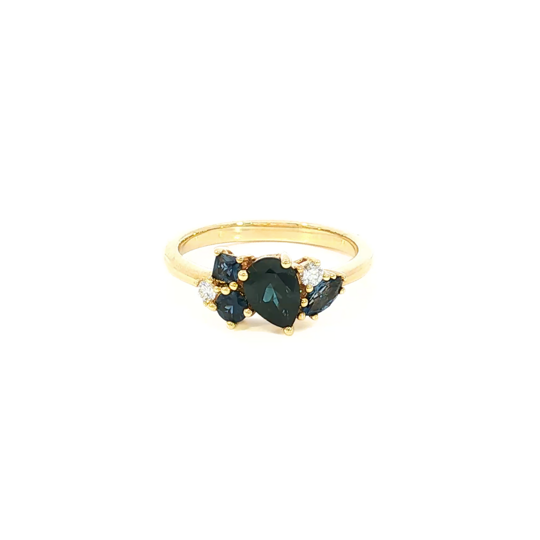 18ct yellow gold ring featuring a random cluster of Australian blue sapphires in pear, round, and marquise cuts with diamond accents and a post and bezel undercarriage.