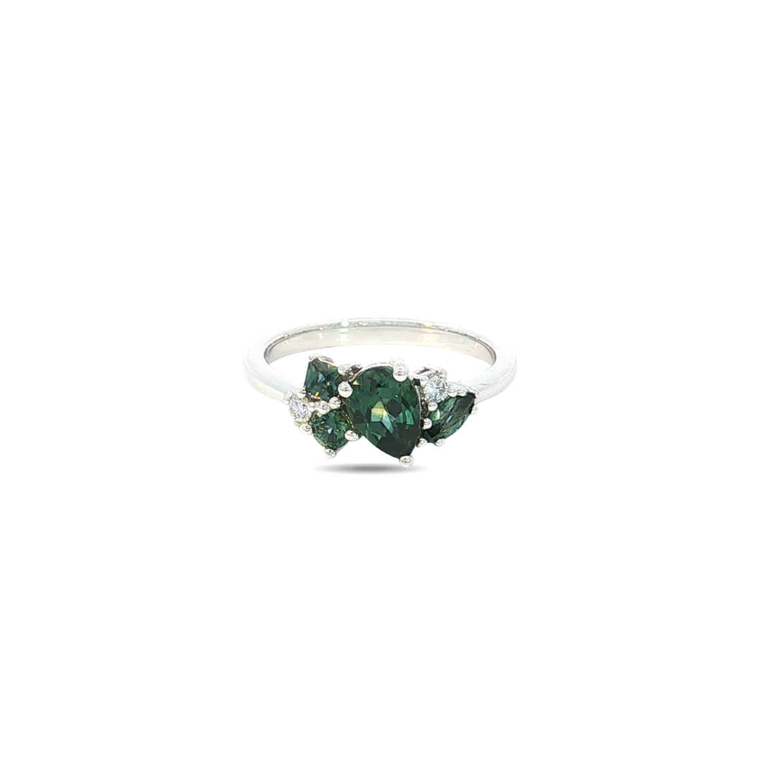 18ct white gold ring featuring a random cluster of Australian teal green sapphires in pear, round, and marquise cuts with diamond accents and a post and bezel undercarriage.
