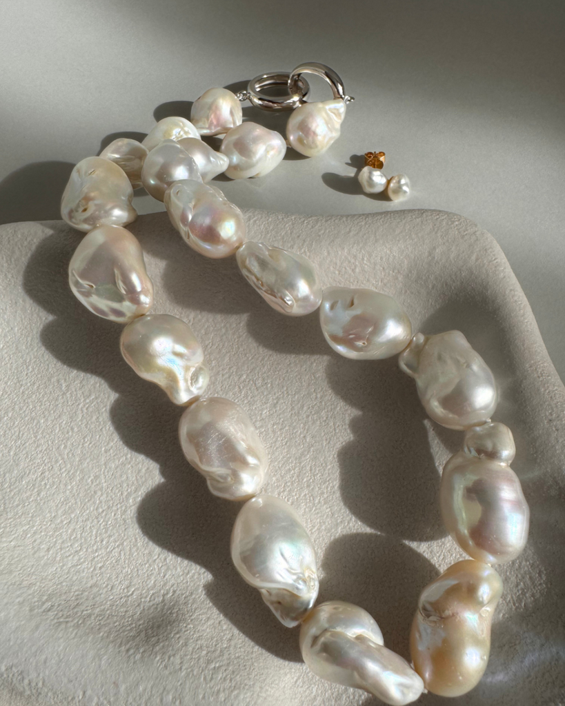 Strand of 19 freshwater baroque pearls measuring 14–18mm, individually knotted and finished with a sterling silver double oval link clasp.