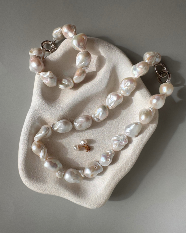 Strand of 19 freshwater baroque pearls measuring 14–18mm, individually knotted and finished with a sterling silver double oval link clasp.