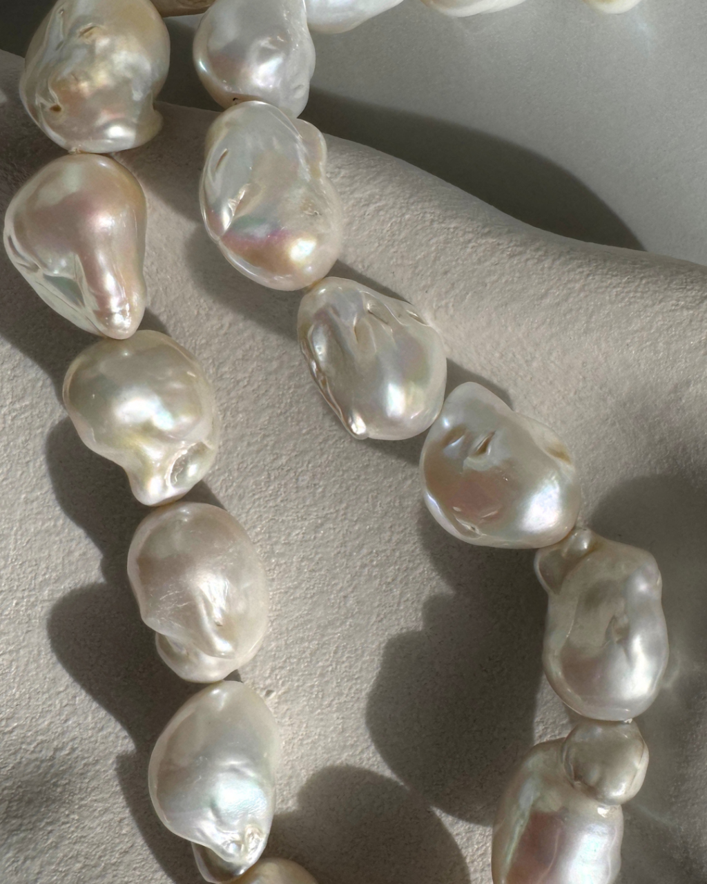 Strand of 19 freshwater baroque pearls measuring 14–18mm, individually knotted and finished with a sterling silver double oval link clasp.