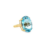 9ct yellow gold ring featuring a 23.70 x 17.75mm oval cut blue topaz in a four-claw setting with engraved shoulders.