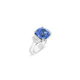 18ct white gold three stone ring featuring an 8.07ct cushion cut blue sapphire with cadillac cut diamond side stones and sapphire-diamond accents in the undercarriage.
