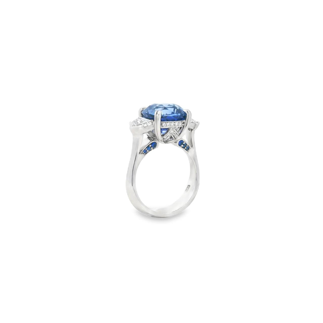 18ct white gold three stone ring featuring an 8.07ct cushion cut blue sapphire with cadillac cut diamond side stones and sapphire-diamond accents in the undercarriage.
