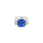 18ct white gold three stone ring featuring an 8.07ct cushion cut blue sapphire with cadillac cut diamond side stones and sapphire-diamond accents in the undercarriage.