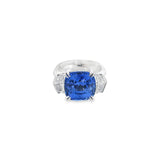 18ct white gold three stone ring featuring an 8.07ct cushion cut blue sapphire with cadillac cut diamond side stones and sapphire-diamond accents in the undercarriage.