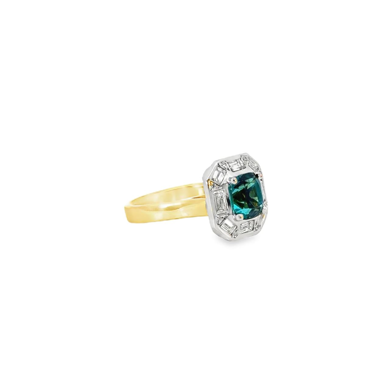18ct yellow and white gold ring featuring a 1.88ct cushion cut greenish-blue tourmaline surrounded by baguette and round brilliant cut diamonds in an octagonal cluster design.