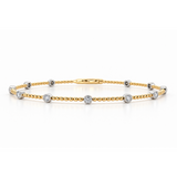 18ct yellow gold beaded bangle featuring eleven round brilliant cut diamonds in contrasting white gold bezel settings, totalling 0.38ct.