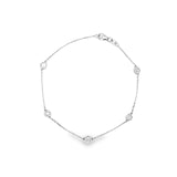 18ct white gold diamond bracelet featuring a fine trace link chain, central circular mini disc with bead-set diamond cluster, bezel-set diamonds along the length, and an adjustable parrot clasp.