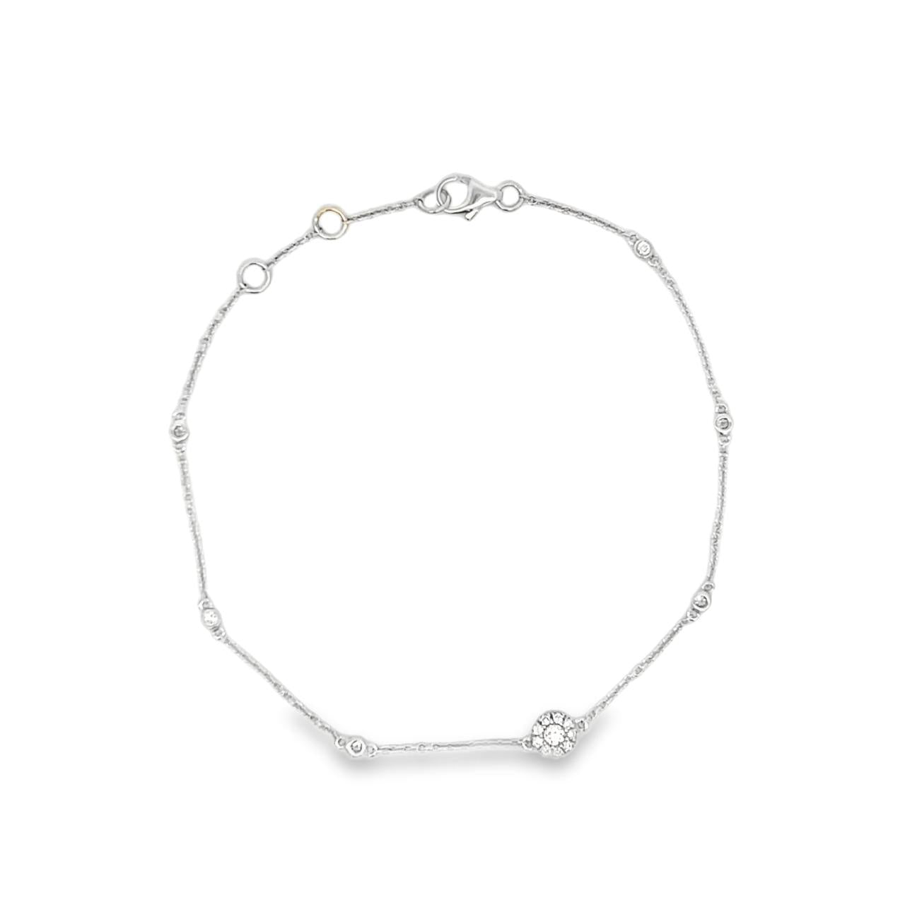 18ct white gold diamond bracelet featuring a fine trace link chain, central circular mini disc with bead-set diamond cluster, bezel-set diamonds along the length, and an adjustable parrot clasp.