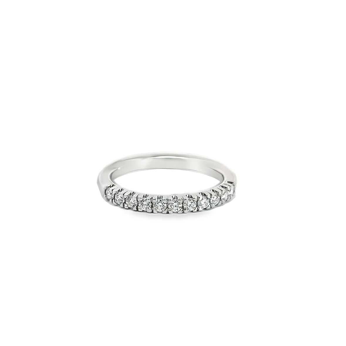 Platinum wedding ring featuring eleven claw-set round brilliant cut diamonds across the top of the band.