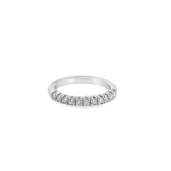 Platinum wedding ring featuring eleven claw-set round brilliant cut diamonds across the top of the band.