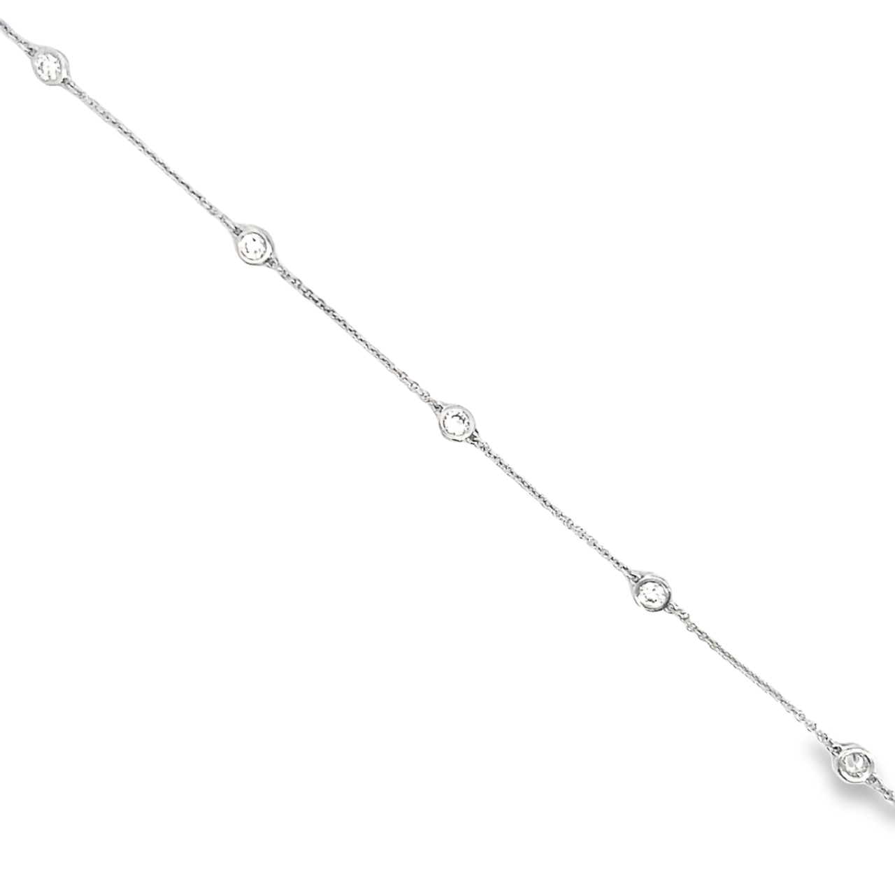 18ct white gold diamond station bracelet featuring five bezel-set round brilliant cut diamonds evenly spaced along a fine 19cm trace link chain.