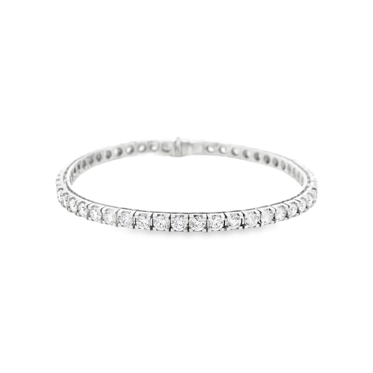 18ct white gold diamond tennis bracelet featuring fifty-one round brilliant cut diamonds totalling 5.51ct, in classic four-claw settings with a secure slide catch and fold-over clasp.