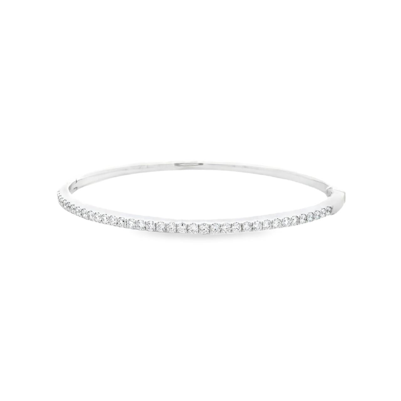 18ct white gold diamond bangle featuring thirty-six claw-set round brilliant cut diamonds across the top, hinged oval profile with secure slide catch and fold-over clasp.