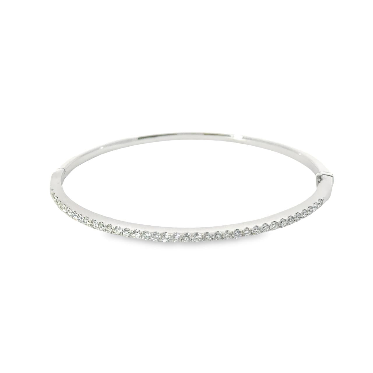 18ct white gold diamond bangle featuring thirty-six claw-set round brilliant cut diamonds across the top, hinged oval profile with secure slide catch and fold-over clasp.