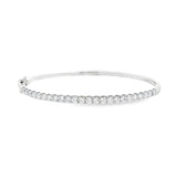 18ct white gold diamond bangle featuring claw-set round brilliant cut diamonds across the top, hinged oval profile with slide catch and safety clasps.