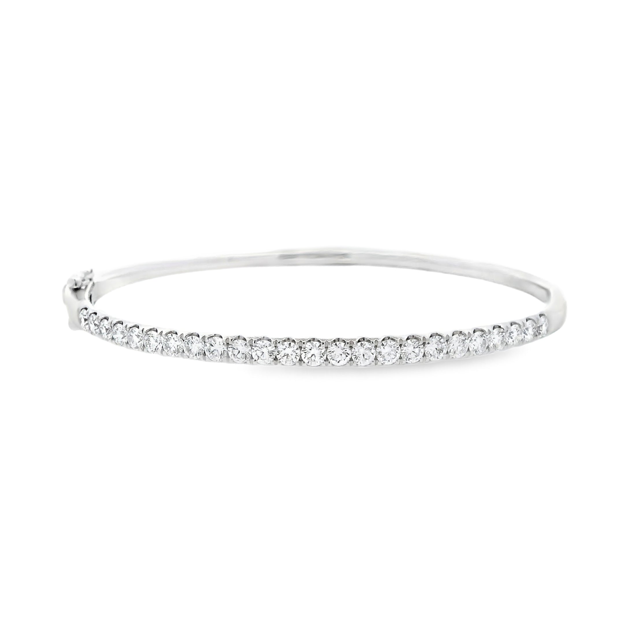 18ct white gold diamond bangle featuring claw-set round brilliant cut diamonds across the top, hinged oval profile with slide catch and safety clasps.