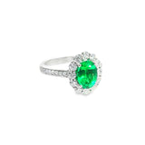 18ct white gold emerald and diamond halo ring featuring an oval emerald with a scalloped diamond surround and bead-set shoulders, size N (resizeable).
