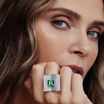 Platinum emerald and diamond ring featuring a 2.93ct emerald-cut centre stone with pavé diamond open book–style surround.