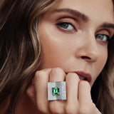 Platinum emerald and diamond ring featuring a 2.93ct emerald-cut centre stone with pavé diamond open book–style surround.