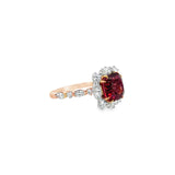 18ct rose gold ring featuring a 4.55ct cushion Malaya garnet with alternating marquise and round diamond clusters surrounding the centre stone and along the shoulders.