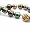 Strand of forty-one graduated Tahitian pearls ranging from 8.60mm to 10.85mm, dark silver to deep purple-green tones, finished with an 18ct yellow and white gold diamond-set clasp.