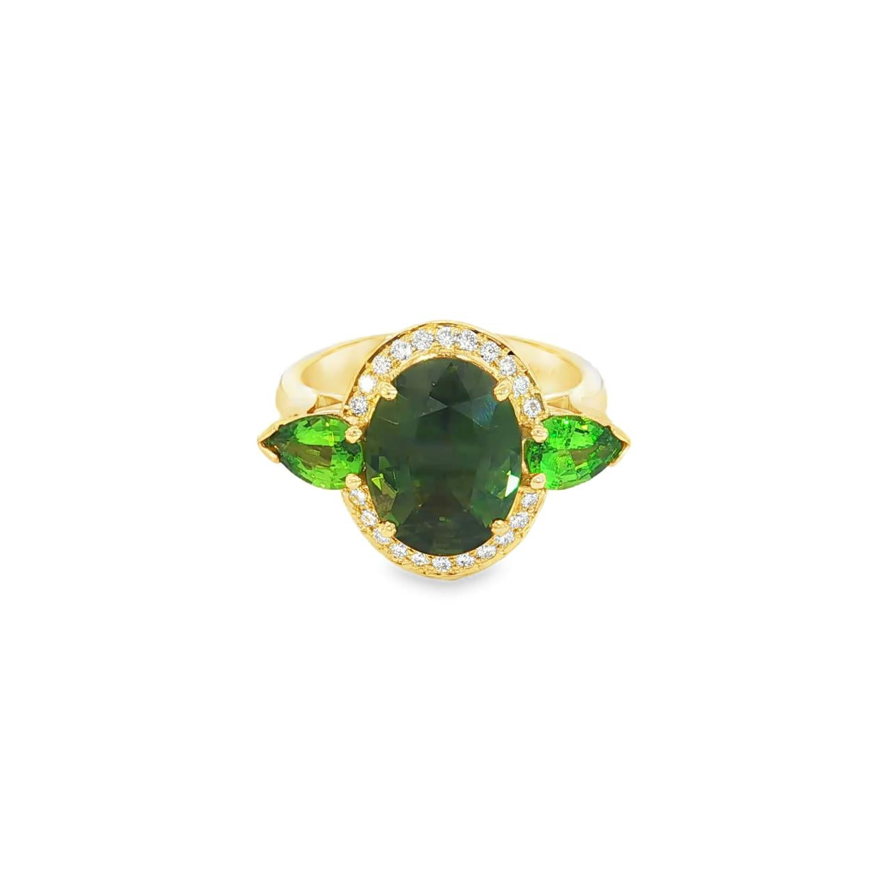 18ct yellow gold ring featuring oval green sapphire, tsavorite garnets, and diamond halo design with intricate undercarriage detail.