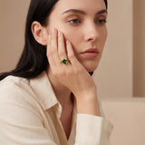 18ct yellow gold ring featuring oval green sapphire, tsavorite garnets, and diamond halo design with intricate undercarriage detail.